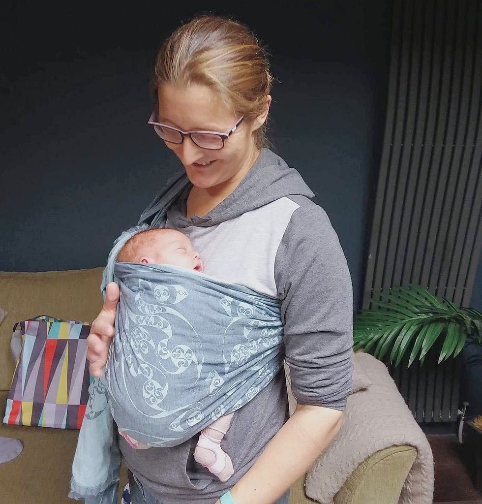 Mum using a ring sling with her newborn